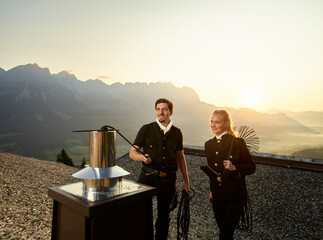 Chimney sweepers cleaning chimney on rooftop at sunrise