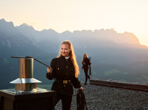 Smiling chimney sweeper standing on rooftop