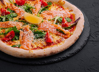 Gourmet smoked salmon pizza on dark background
