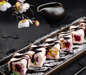 Gourmet fruit sushi rolls on elegant slate plate