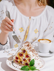 Woman enjoying delicious pavlova dessert at cafe
