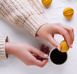 Hand picking a cookie with coffee on table