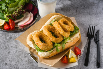 Deep fried squid in bread with greens on the side. Squid sandwich