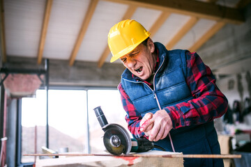 Sawing into finger with circular saw. Injured worker with wound hand. Work injury, accident in workplace.