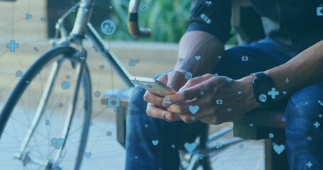 Biracial young professional holding smartphone, sitting near bike - Powered by Adobe