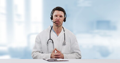 Image of caucasian male doctor on image consultation wearing phone headset with stethoscope