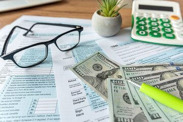 accounting paperwork individual tax form 1040 glasses dollar and pen on desk
