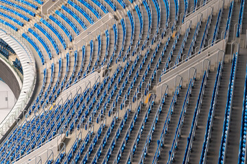 Panoramic shot of expansive blue stadium seats arranged in rows, depicting the scale and design of a modern sports arena.