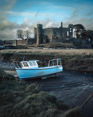 boat on the river in front of Laugharne Castle, Carmarthenshire, South Wales, Wales