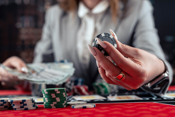 Excited business woman in suit playing poker in casino