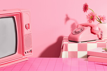 Pink concept photo with frontal shot, a television with pink color, a pink desk phone placed on the...