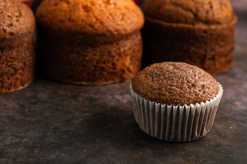 Cupcake and small freshly baked cakes in the background. Pastry table.