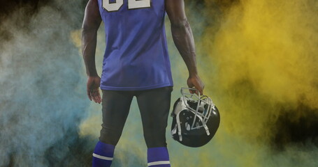 Image of colourful powders over american football player