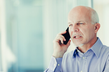 Mature man discusses business on phone outdoors