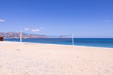 Photo of the beautiful beach in Albir, Altea, Alicante in Spain showing a volleyball net on the beach front by the ocean on the beach known as Playa de Cap Blanch