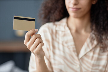 Crop shot of hand of young biracial woman holding credit card, copy space