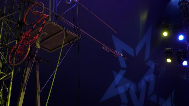 Equipment for tightrope walkers in the circus before performing under concert lighting. Long sticks and a bike for rope stunts. Circus equipment and colorful days before the performance of the artists
