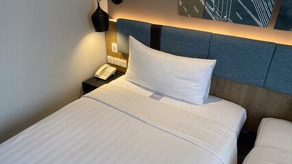a bed with white sheets and white pillows with a white pillow on it