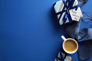 Festive flat lay composition with coffee, gifts, glasses, and tie on blue backdrop - perfect for Father’s Day promotions and morning vibes