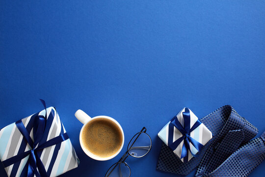 Vibrant blue flat lay with coffee, eyeglasses, and striped gift boxes - ideal for Fathers Day holiday theme