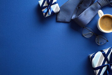 Fat lay composition with gift boxes, coffee cup, and eyeglasses on a blue background. Fathers Day...