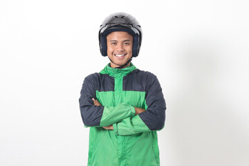 Portrait of Asian online taxi driver wearing green jacket and helmet, standing with crossed arms. Isolated image on white background