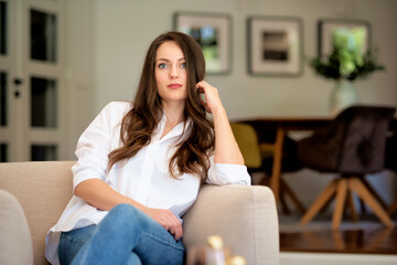 Portrait of a brunette haired woman relaxing in an armchair at home