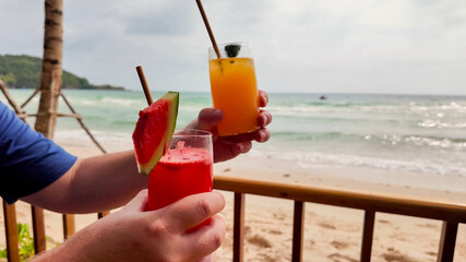 Refreshing morning drinks on a tropical beachside cafe table with a serene sea view, perfect for travel, summer vacation, and leisure lifestyle concepts