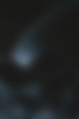 Dark grainy gradient texture post background template, shine bright light and glow backdrop, faint light source emanating through the darkness