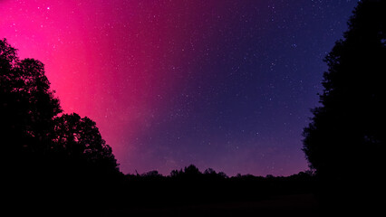 Star filled night sky illuminated by the bright magentas of the Aurora Borealis over the Dordogne...