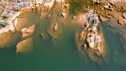 Tranquil freshwater lake with submerged and exposed brown rocks, suitable for themes like nature...