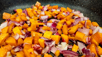 Close-up of colorful diced vegetables sauteing in a pan, perfect for healthy eating concepts and vegetarian recipe content during National Nutrition Month