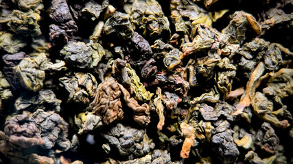 Close-up of dried loose green tea leaves, ideal for culinary blogs or articles about International Tea Day and healthful beverages