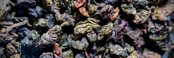 Close-up of dried loose green tea leaves, ideal for culinary blogs or articles about International Tea Day and healthful beverages