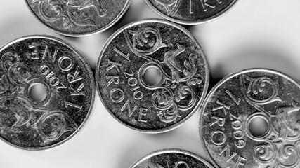 Close-up of various Danish 1 Krone coins scattered on a surface, suitable for financial concepts,...