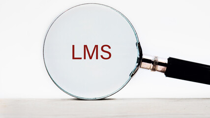 Word cloud concept. LMS - Learning Management System acronym text appeared through a magnifying...