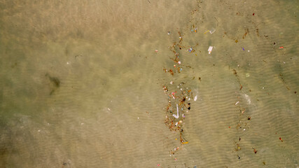Aerial view of a polluted water body with scattered trash, highlighting environmental issues and the need for conservation around World Water Day and Earth Day