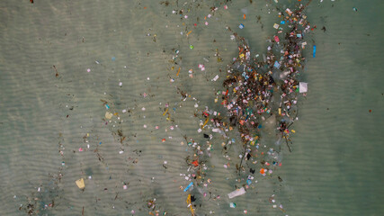 Aerial view of a polluted water body with scattered trash, highlighting environmental issues and...