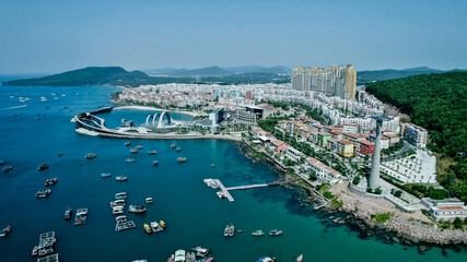 Fototapeta premium Aerial view of a bustling coastal city with modern architecture and a marina, ideal for travel, urban development, and holiday themes