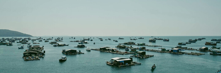 A serene coastal aquafarm with scattered fishing boats on a calm sea, encapsulating the essence of maritime livelihood and sustainable fishery practices