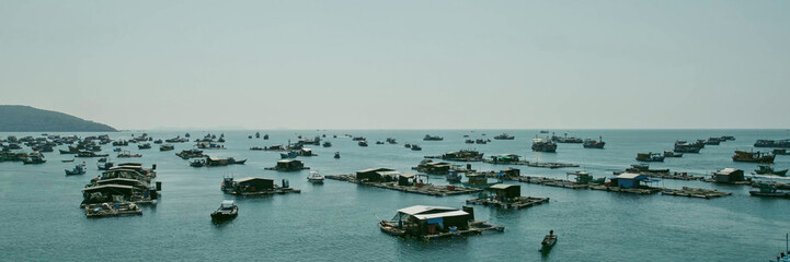 A serene coastal aquafarm with scattered fishing boats on a calm sea, encapsulating the essence of...