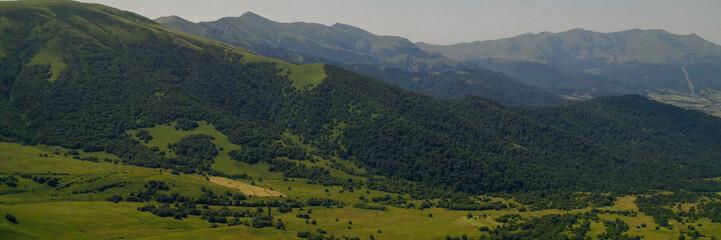 Breathtaking panoramic view of vibrant green meadows, ideal for nature and travel themes, Earth Day...