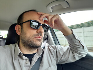 Uomo alla guida della propria automobile per le strade della città