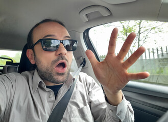 Uomo alla guida della propria automobile per le strade della città