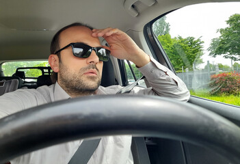 Uomo alla guida della propria automobile per le strade della città