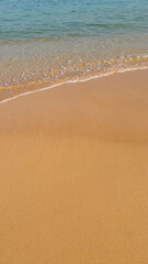 Tranquil sandy beach with gentle waves, ideal for travel and summer vacation concepts, potentially related to World Oceans Day