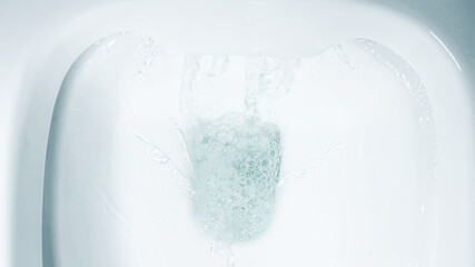 Close-up of clear water flushing in a white toilet bowl, concept for hygiene, cleaning, and World...