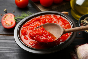 Eating homemade tomato sauce at black table, closeup