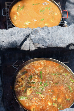 top view of two exquisite typical Spanish paellas cooking over an open fire in the field