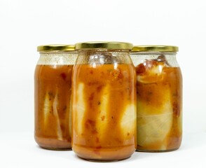 Glass jars of stuffed cabbage tomato sauce isolated on a white background